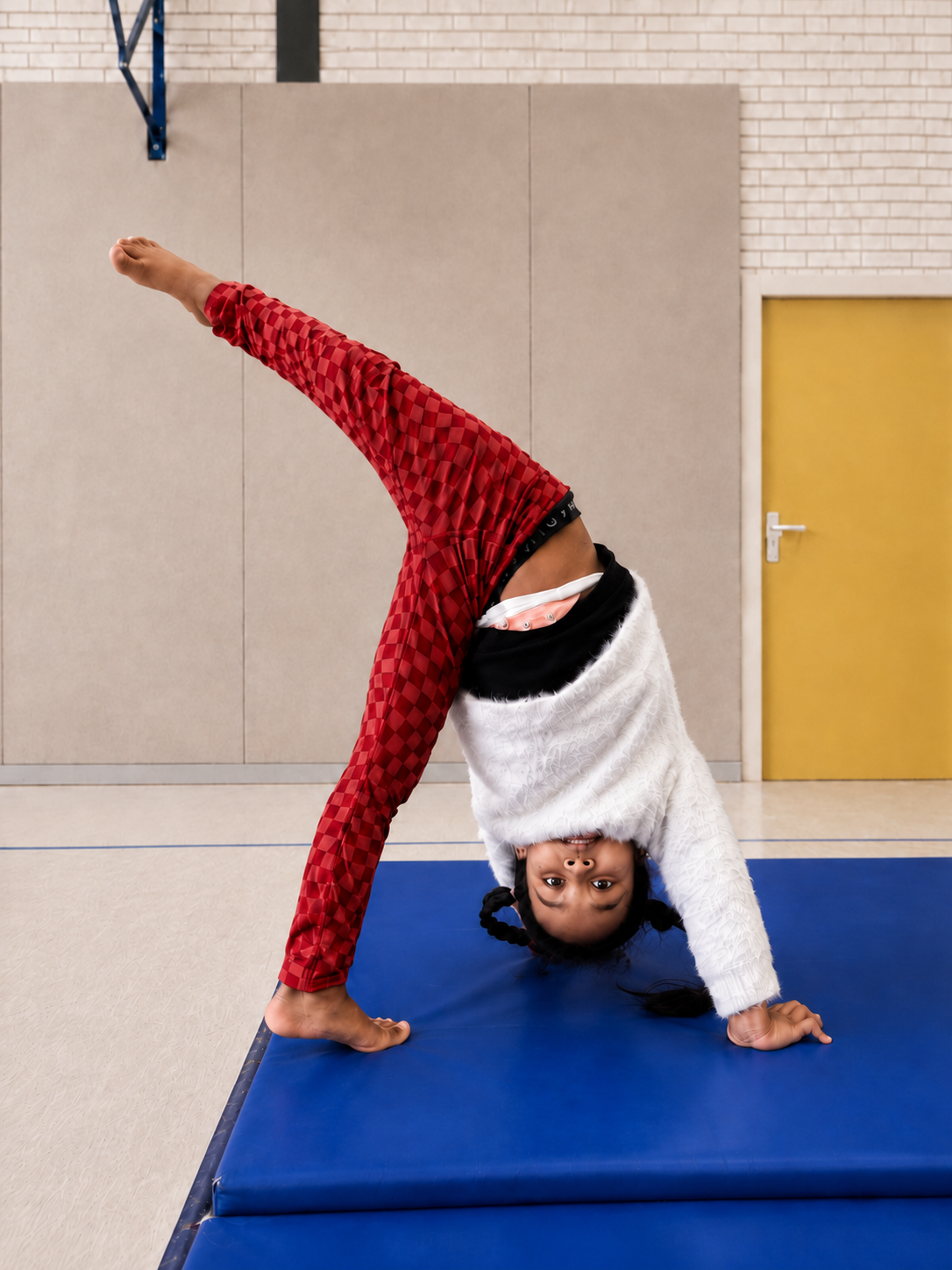 Kind oefent een creatieve acro-move op de mat
