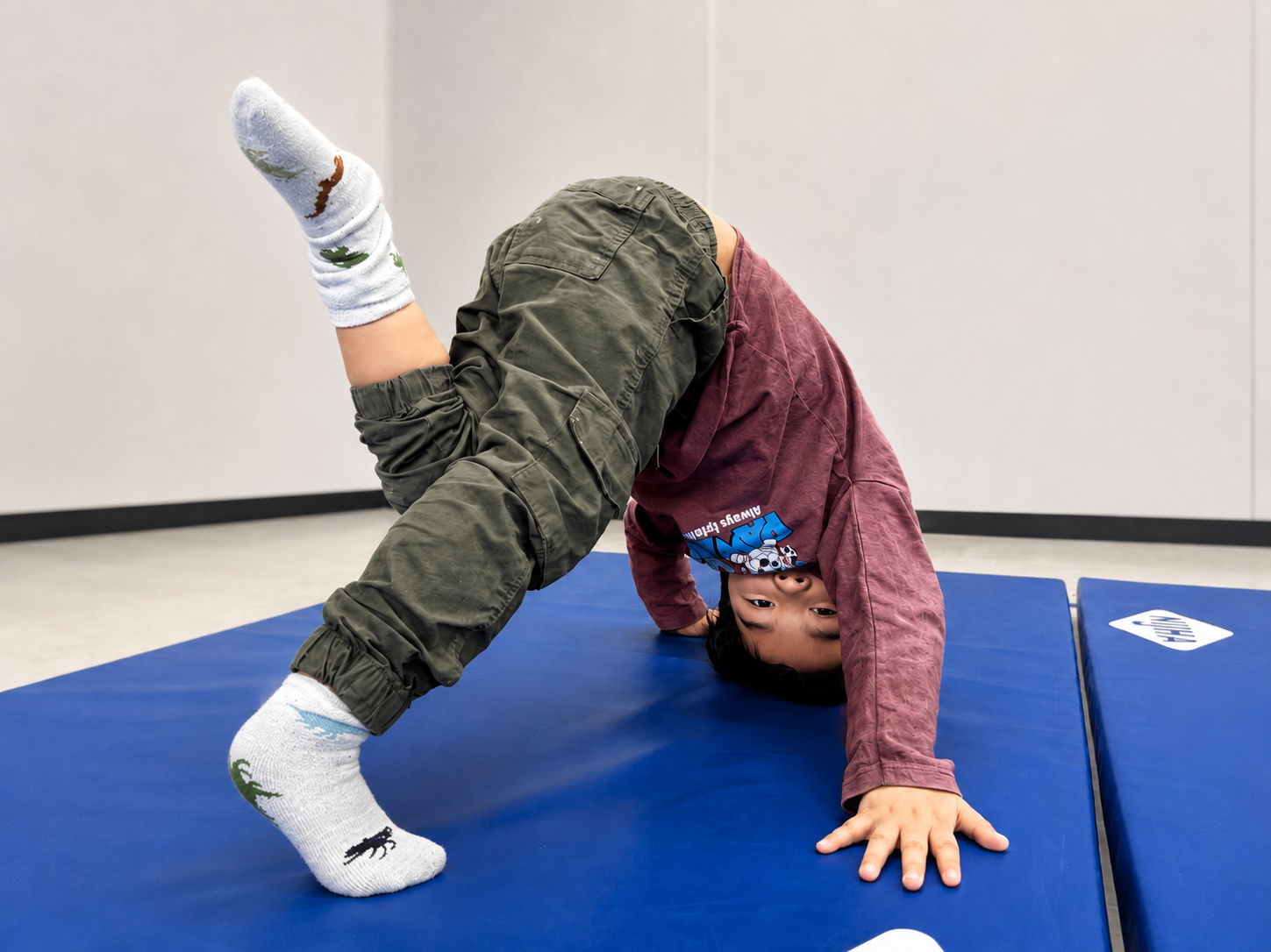 Kind oefent een creatieve acro houding op de mat